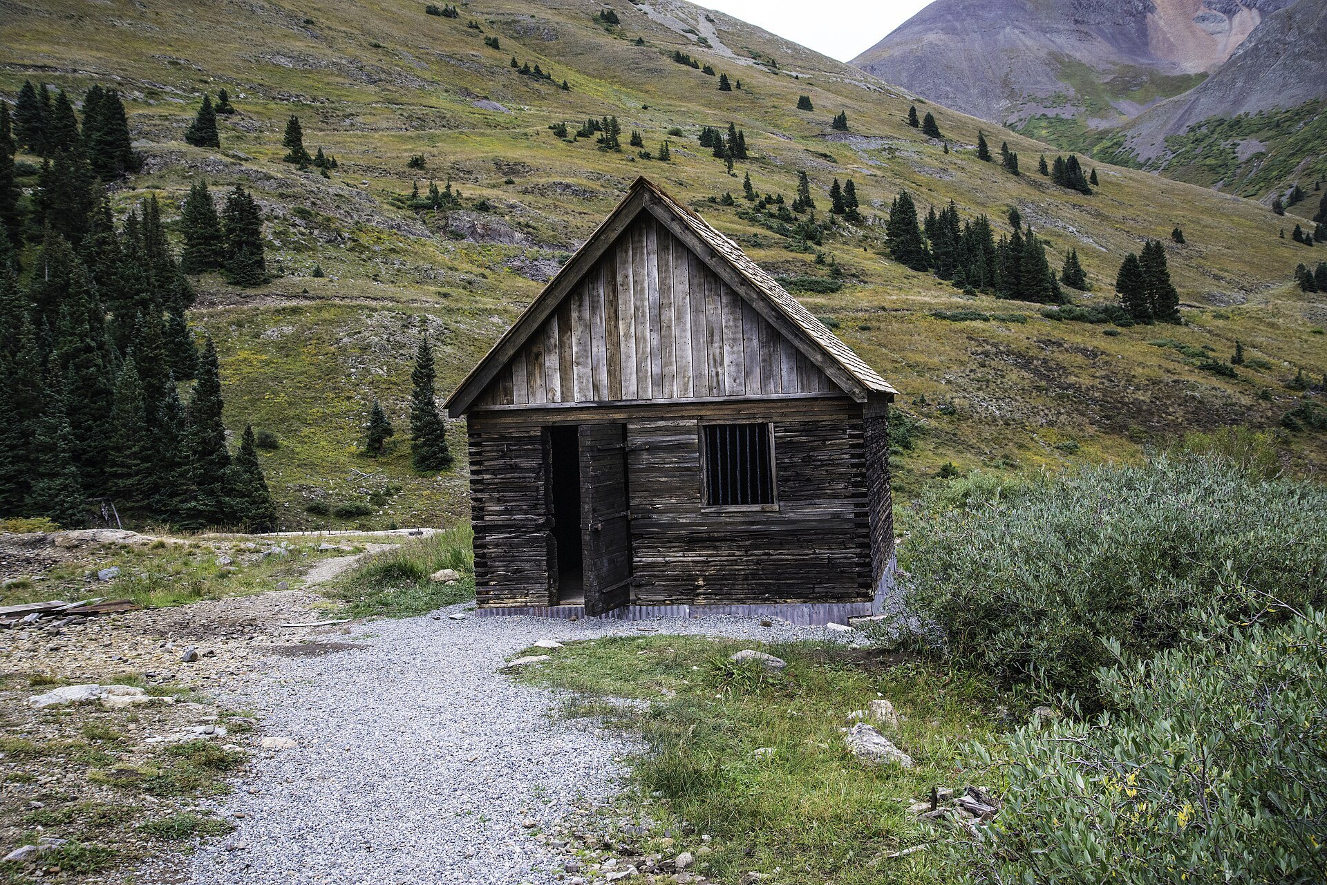 Weathered log cabin beside the gravel path at Animas Forks
