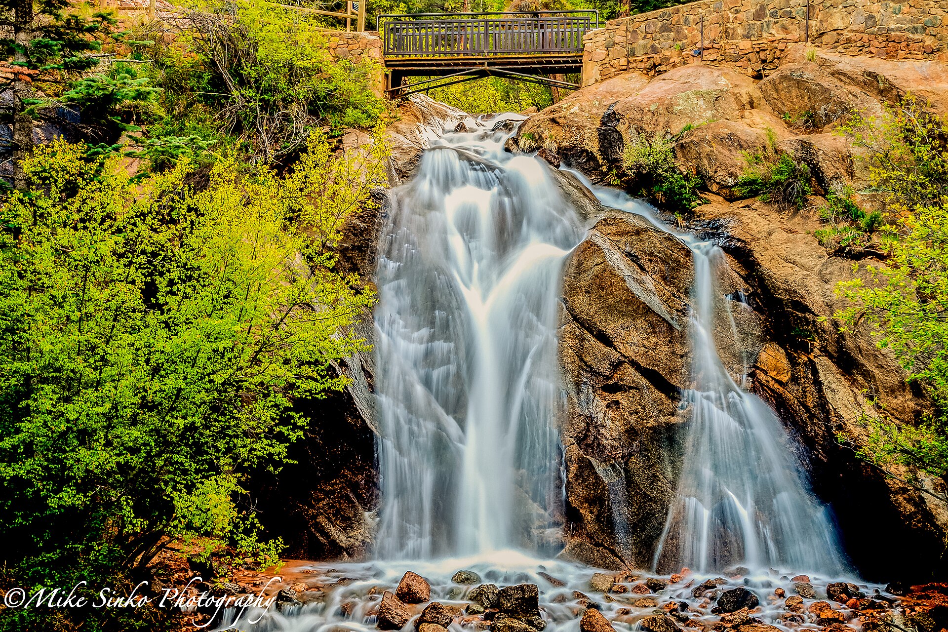 Long exposure of Helen Hunt Falls with green summer foliage